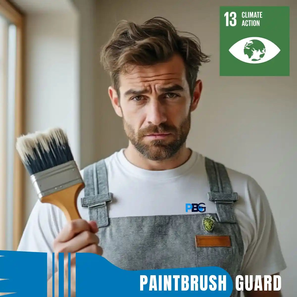 Man holding a paintbrush with 'Paintbrush Guard' branding, wearing overalls, and standing indoors.