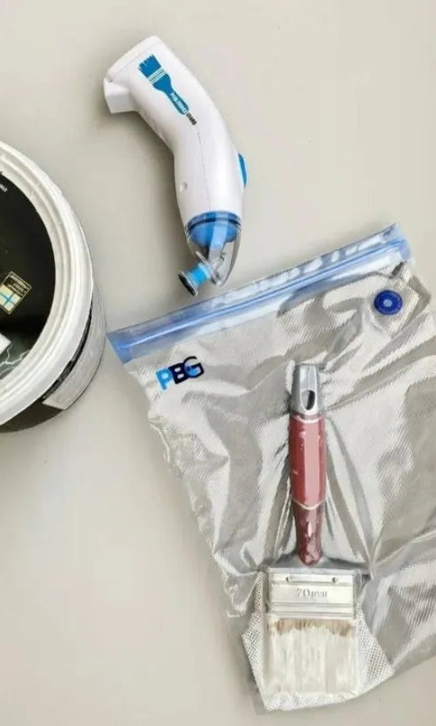 Cleaning tools including a brush, squeegee, and vacuum cleaner head on a light surface.