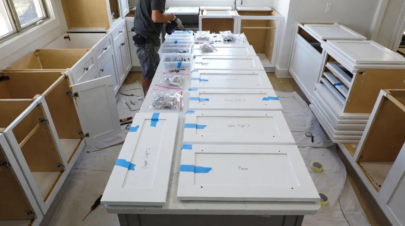 Unassembled kitchen cabinets on a table with a person in the background.